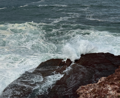 Ocean waves crashing against rugged rocks on the shoreline